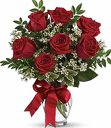 Mazzo di 7 grandi rose rosse con verde decorativo e confezione elegante. Ideale per esprimere amore e affetto in qualsiasi occasione speciale.